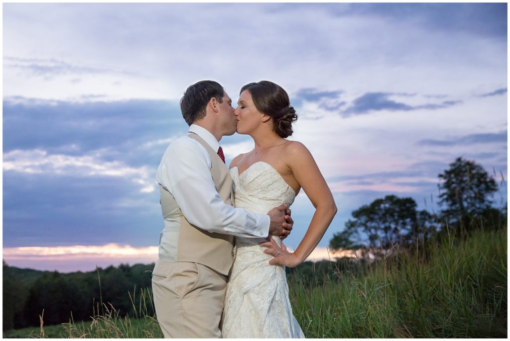 Bride and groom share a kiss at Sunset ion the hilltop of Preston Ridge Vineyard.