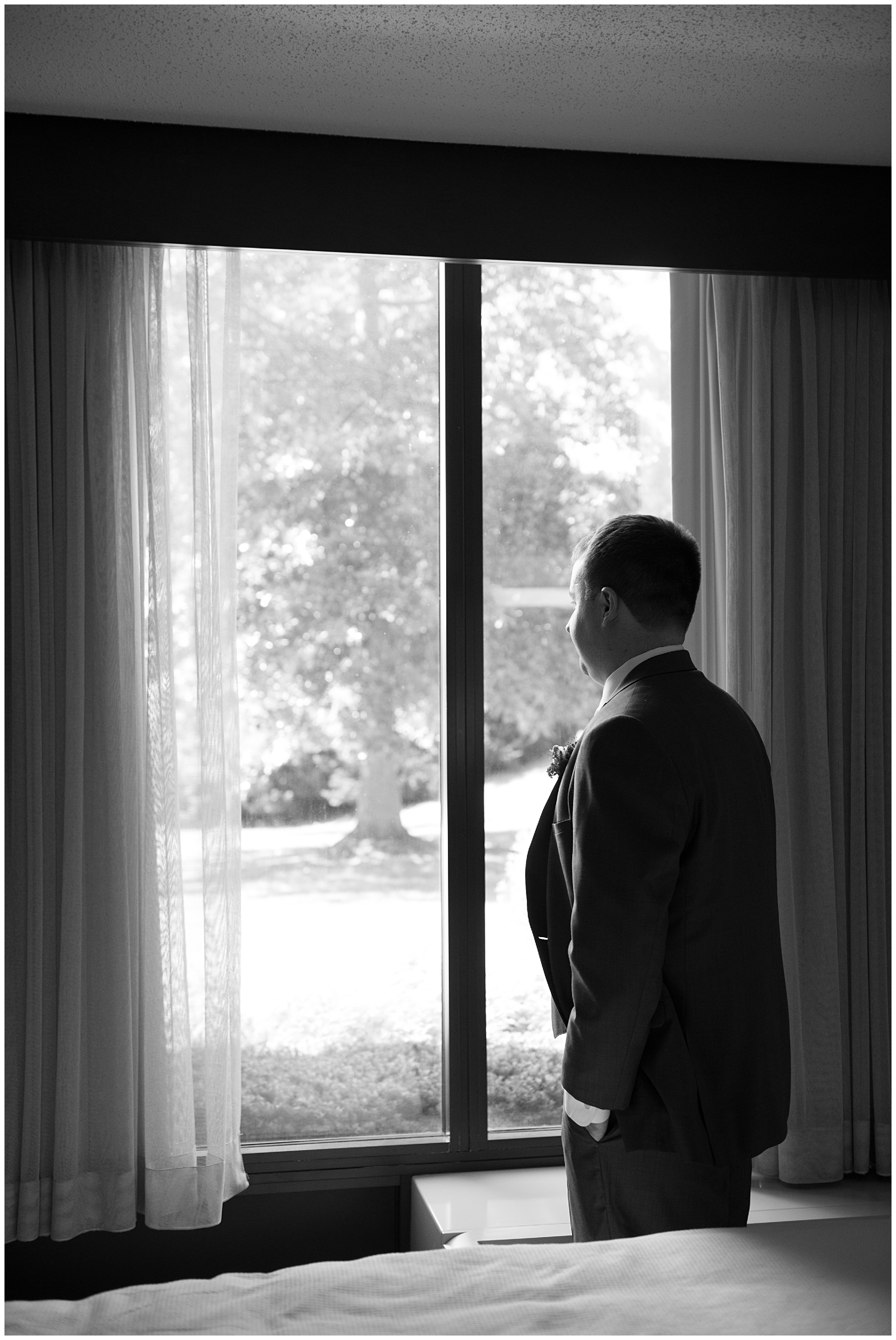 The groom looks out a window 