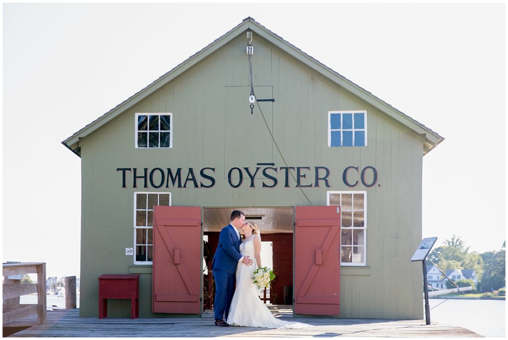 Bride and groom kiss in front of the Thomas Oyster CO Building
