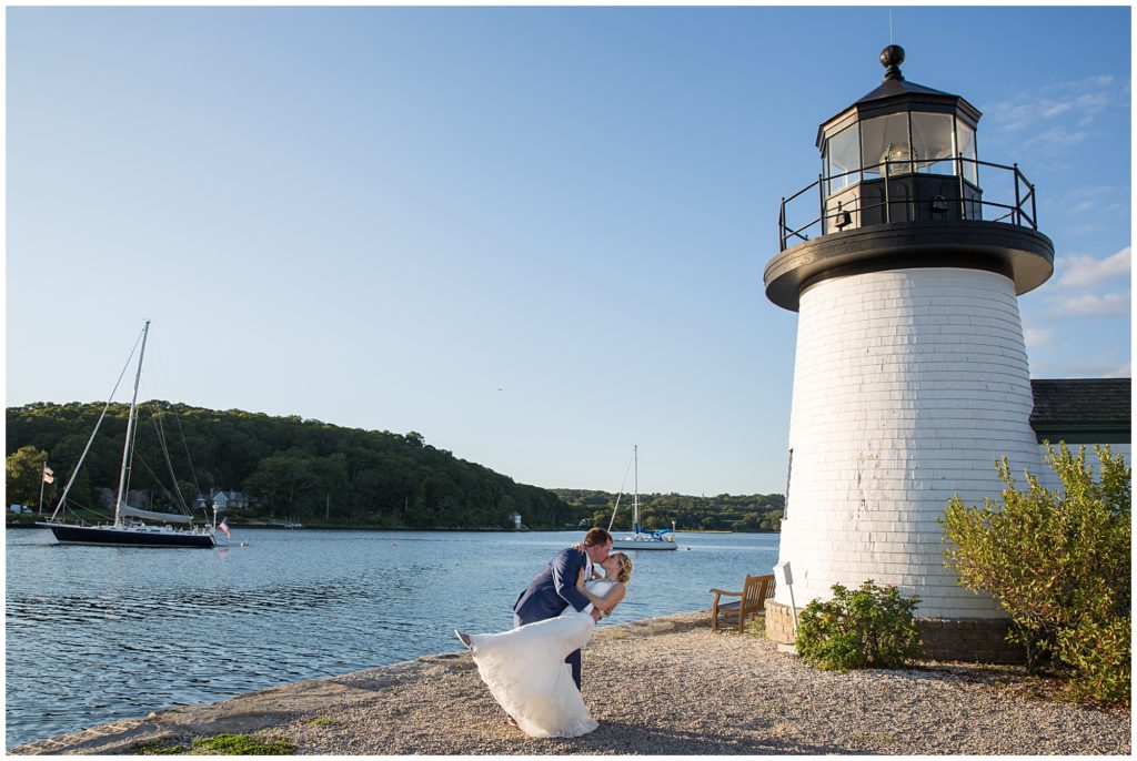 Bride and Groom kiss under the lighthouse at the Mystic Seaport Museum in Mystic Connecticut. 