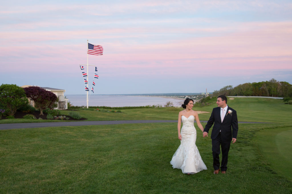 A bride and groom go for a sunset walk during their wedding at White Cliffs Country Club in Plymouth MA.