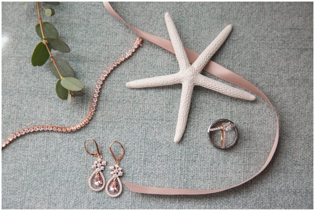Nautical bridal lay flat featuring rose gold bridal jewelry and wedding rings. 