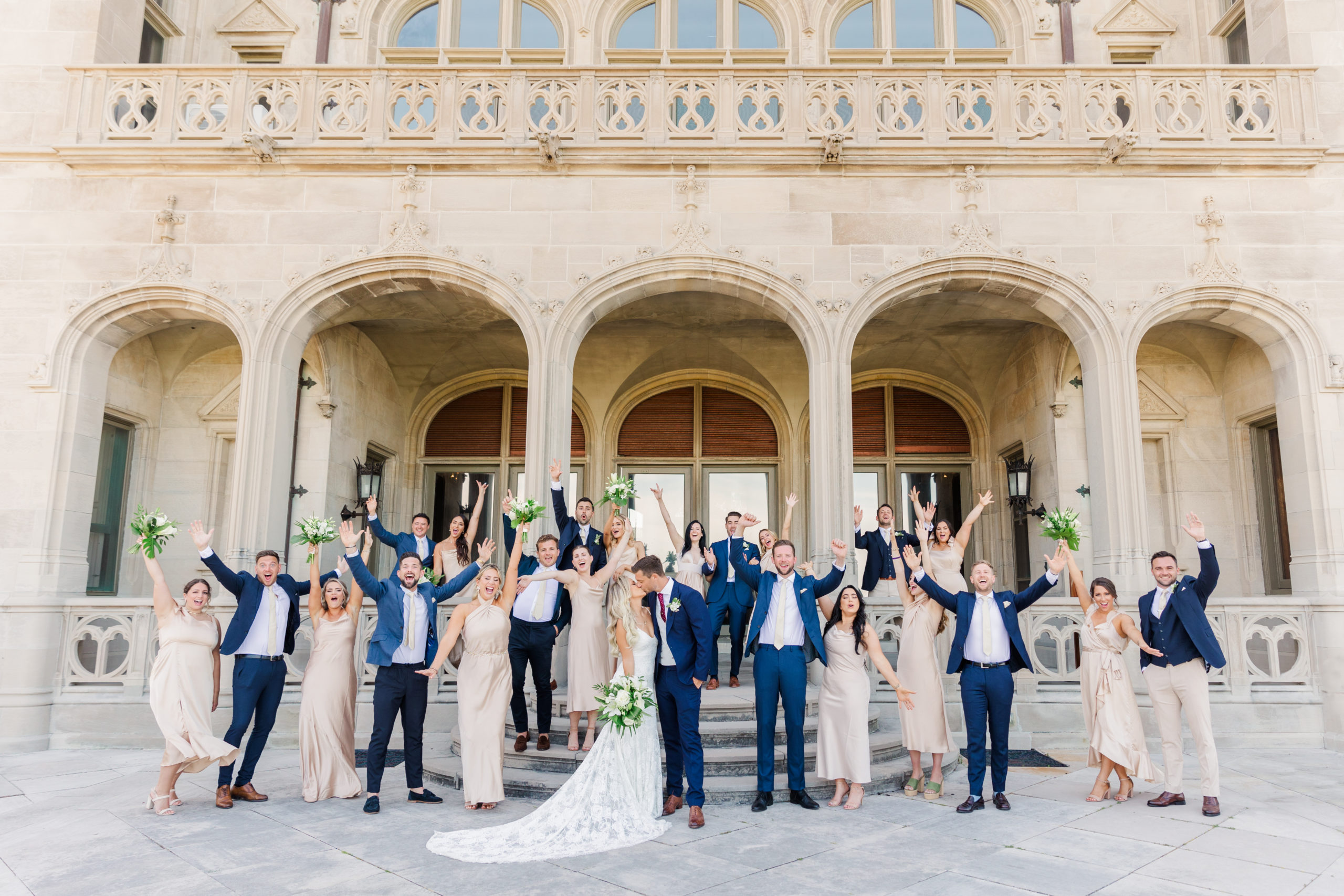 Bridal Party cheers for the bride and groom on the steps of Ochre Court in Newport Rhode Island.